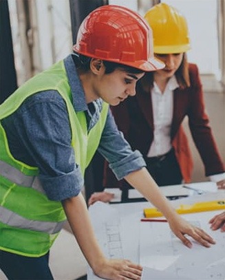 Engineers reviewing blueprints at a construction site.