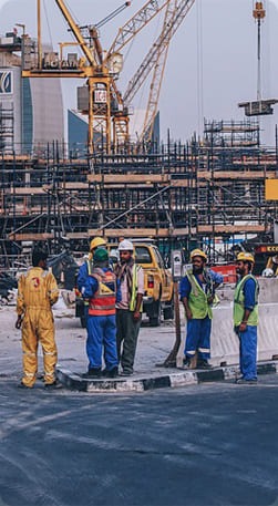 Construction workers and engineers at a busy construction site, representing professional construction services.