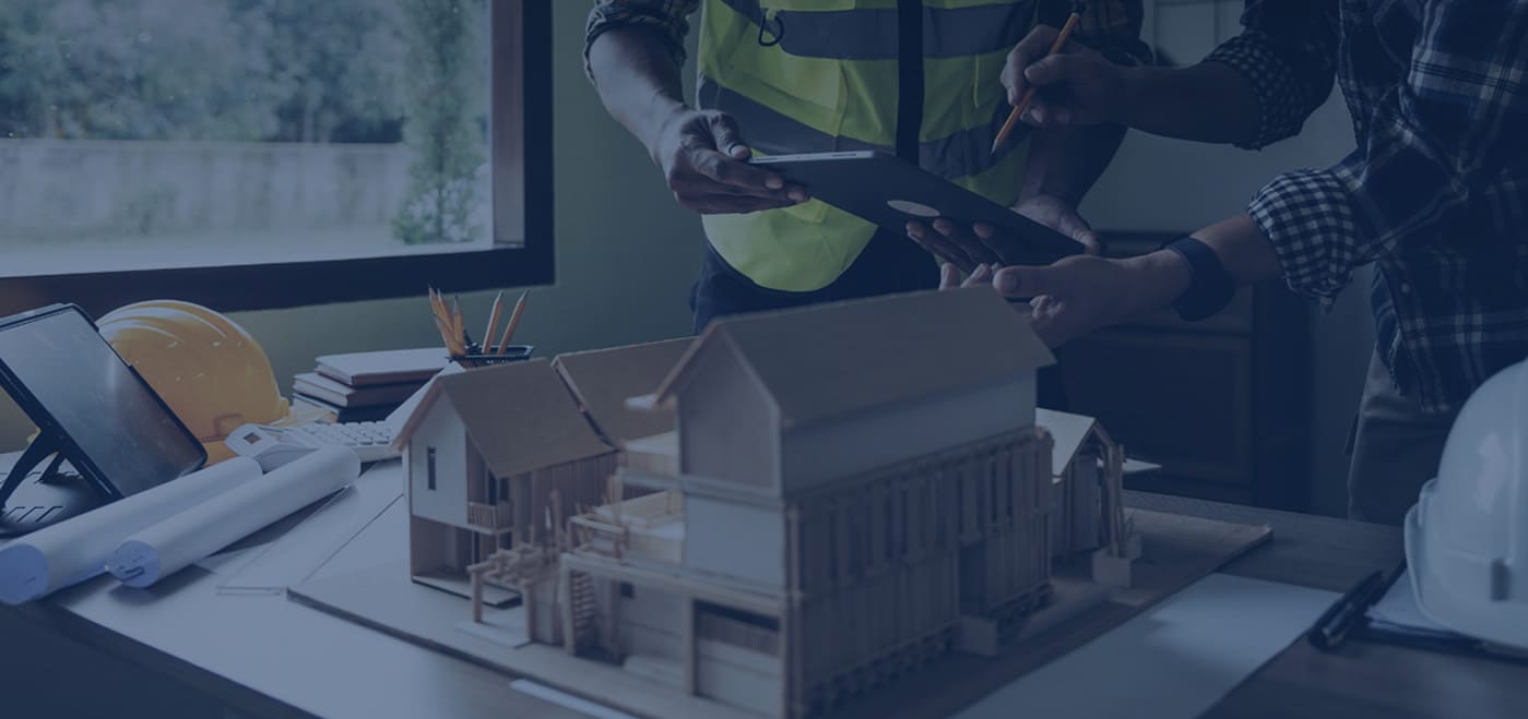 Engineers discussing construction plans with architectural model